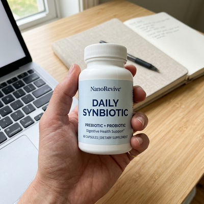 Daily Synbiotic bottle held in hand at a desk